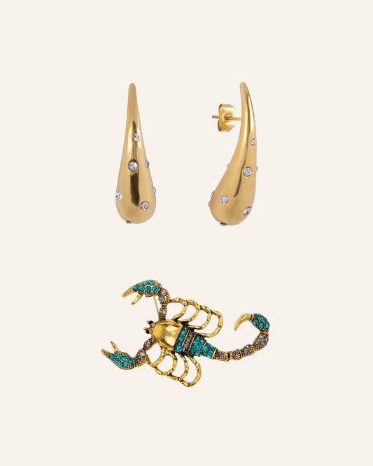 Set van gouden oorbellen met steentjes en gouden scorpio broche met turquoise rhinestone - MAE.FAE The Label
